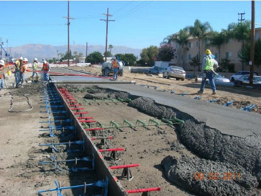 Obreros de la construcción ponen concreto sobre la superficie de lo que será el carril exclusivo de autobuses en la extensión Canoga de la Línea Naranja del Metro. (Foto Metro Construction).