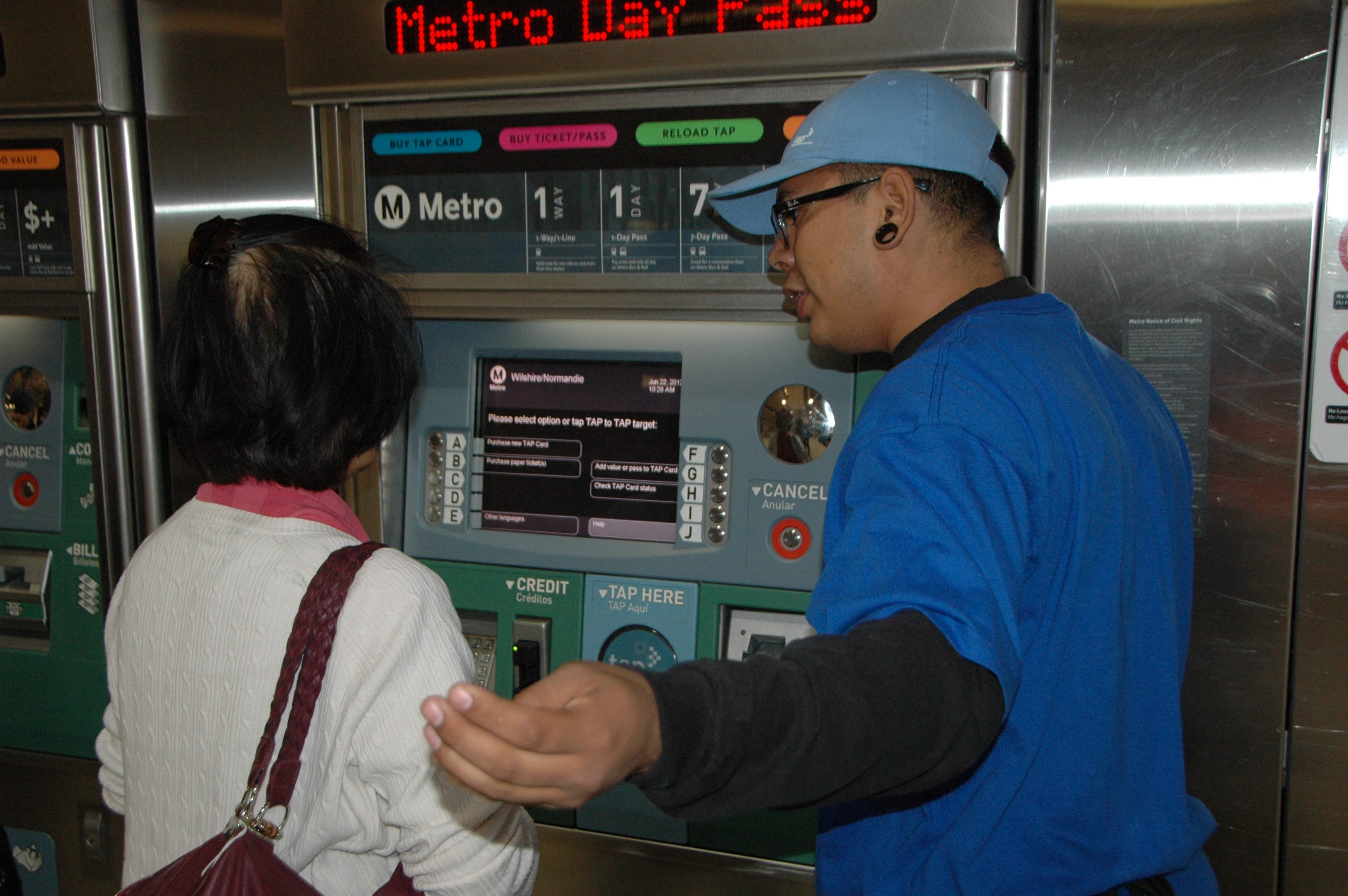 Empleado de Metro ayuda a una persona a comprar la tarjeta TAP en la estación Normandie de la Línea Morada del Metro.
