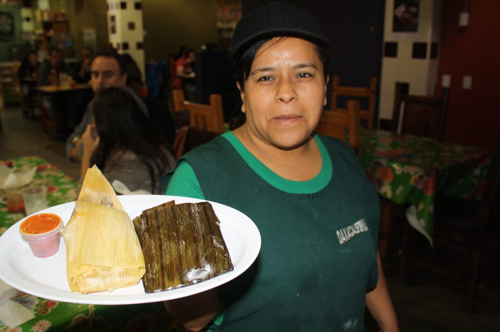 Isela Andrés, del restaurante Oaxacalifornia nos muestra los tamales de mole y de frijol. (Foto de Agustín Durán/El Pasajero)
