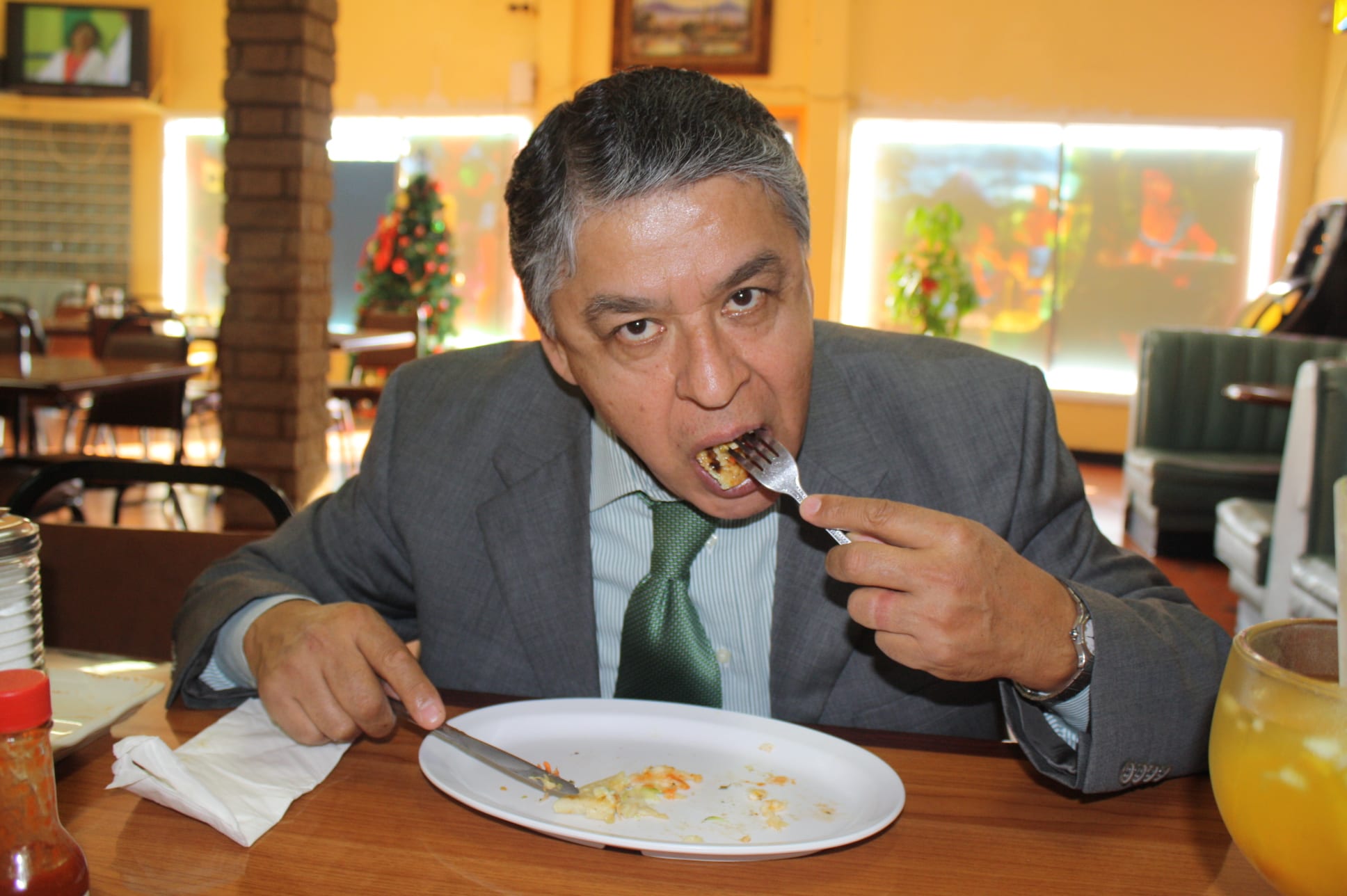 Carlos Serrano atrapado en el momento de “ataque” contra una pupusa de camarón con queso. (Foto de Agustín Durán/El Pasajero).